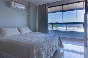 Postel nebo postele na pokoji v ubytování Frente Mar Incrível - Acorde com o Som das Ondas!