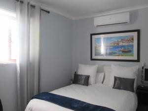 a bedroom with a bed and a picture on the wall at Villa Armaan in Brackenfell