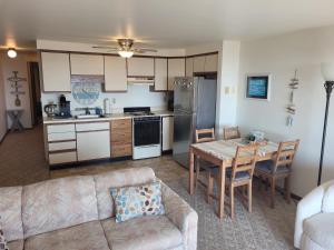 una cucina e un soggiorno con un divano e un tavolo di New! Carpe Diem 365 - Very Cute Lakefront Condo! a Oscoda