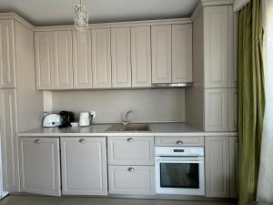 a kitchen with white cabinets and a sink at SIBIU Bach Penthouse in Sibiu