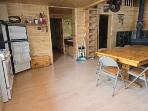 une cuisine et une salle à manger avec une table en bois dans l'établissement Camp Jackson Host Cabin, à Verdure