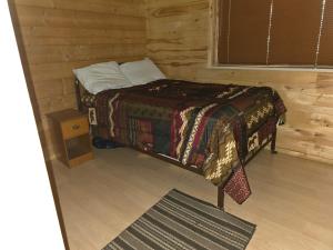 une chambre avec un lit dans une cabane en rondins dans l'établissement Camp Jackson Host Cabin, à Verdure