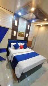 a bedroom with a blue and white bed with blue pillows at Sri Krishna Residency in Varanasi +33 photos