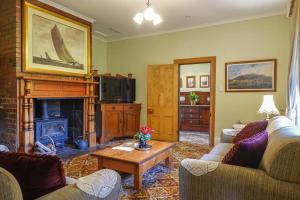 a living room with two couches and a fireplace at Casilda House-Central Waterfront in Dunalley