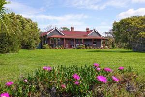 a house with pink flowers in front of it at Casilda House-Central Waterfront in Dunalley