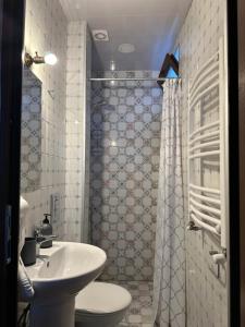 a bathroom with a sink and a toilet and a shower at Smiths house in Surami +31 photos