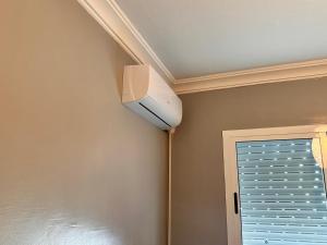 ventilatore a soffitto in una camera con finestra di Modern beach appartment in the heart of Martil a Martil