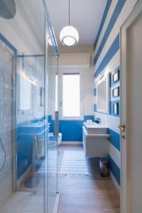 Un baño azul con lavabo y ducha. en Cozy olive green flat, en Florencia