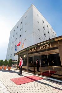 a man standing in front of a gucci hotel at Güneş Hotel Merter in Istanbul