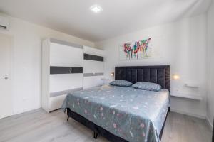 ein Schlafzimmer mit einem Bett in einem weißen Raum in der Unterkunft Villa Perkov private pool in Kaštela + 86 Fotos