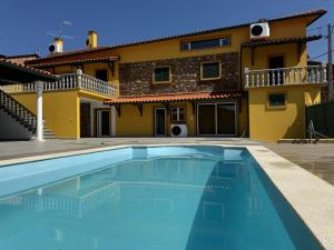 a villa with a swimming pool in front of a house at XperienceHouse Janeiro in Janeiro de Cima