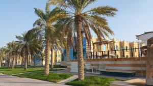 un gruppo di palme davanti a un edificio di Tio Sea Resort ad Al Khor