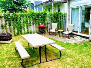 a backyard with a picnic table and chairs and a grill at The House Hotels - W20TH - Three Bedroom, Near West Side Market and Downtown Cle in Cleveland