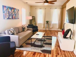 a living room with a couch and a tv at The House Hotels - W20TH - Three Bedroom, Near West Side Market and Downtown Cle in Cleveland
