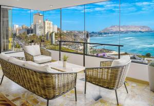 un balcon avec une table et des chaises et une vue sur l'océan dans l'établissement OceanFront Larcomar Apartments, à Lima