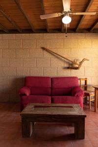 a living room with a red couch and a table at Club JM Lanzarote in Tabayesco