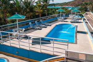 ein Pool auf einem Kreuzfahrtschiff mit Stühlen und Sonnenschirmen in der Unterkunft Fragata Hotel in Guarapari