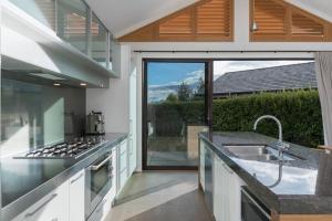 kuchnia ze zlewem i kuchenką górny piekarnik w obiekcie Skye Scape Luxury Retreat - Mountain Views w mieście Frankton