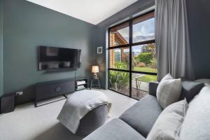 salon z kanapą i dużym oknem w obiekcie Skye Scape Luxury Retreat - Mountain Views w mieście Frankton +15 zdjęć
