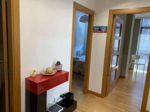 a living room with a red counter and a room at Toxiños in Carballino