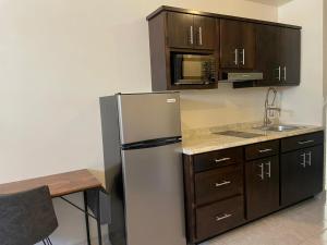 a kitchen with a stainless steel refrigerator and a microwave at Estudios OM in Magdalena de Kino