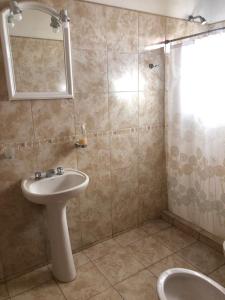 Un baño con lavabo, espejo y ducha. en Cabañas Ipachi Naguan, en Villa Rumipal