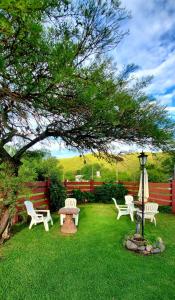 un grupo de sillas, una mesa y un árbol en Cabañas Ipachi Naguan, en Villa Rumipal