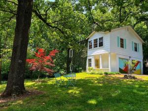 una casa bianca con tavolo e sedie nel cortile di Groovy Getaway Loft, Fast Wi-Fi, Downtown a Fort Payne