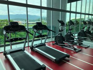 a row of treadmills in a gym with windows at Cozy Family Condo in Petaling Jaya