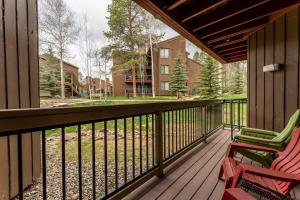 a porch with two chairs and a fence at Wild Irishman #1030 by Summit County Mountain Retreats in Keystone