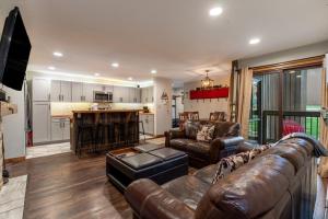 a living room with a leather couch and a kitchen at Wild Irishman #1030 by Summit County Mountain Retreats in Keystone