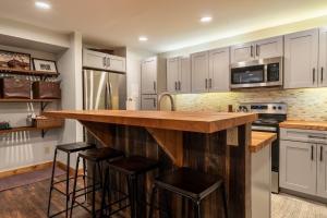 a kitchen with white cabinets and a counter with stools at Wild Irishman #1030 by Summit County Mountain Retreats in Keystone