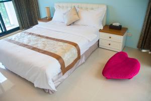 順安村的住宿－海悅灣渡假休閒會館，一间卧室配有一张带红色心椅的床