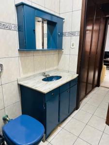 a bathroom with a blue sink and a blue toilet at Casa em Imbituba in Imbituba
