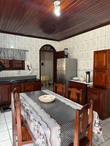 a kitchen with a table and a kitchen with a refrigerator at Casa em Imbituba in Imbituba