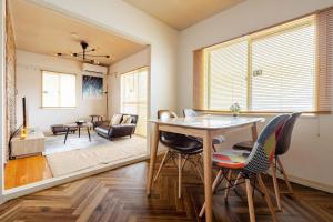 a dining room with a table and chairs and a living room at wood and blue 江ノ島 in Katase