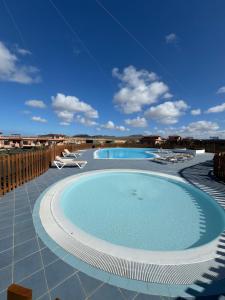 a large swimming pool with chairs on a patio at Casa Bali in Majanicho