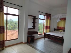 a bedroom with a bed and two large windows at Saga Home in Ambalangoda