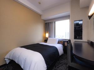 a hotel room with a bed and a large window at APA Hotel Nagoya Sakae in Nagoya