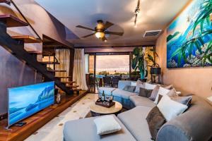a living room with a couch and a tv at El Diria 302- 2 Bedroom Ocean View Condo in Tamarindo