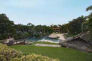 a swimming pool in a resort with trees and grass at El Diria 302- 2 Bedroom Ocean View Condo in Tamarindo