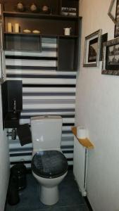a bathroom with a toilet with a black seat at Appartement centre-ville - gîte urbain avec jardin in Bastogne +8 photos