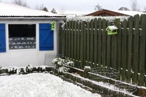 a fence with a light on it in the snow at Appartement centre-ville - gîte urbain avec jardin in Bastogne