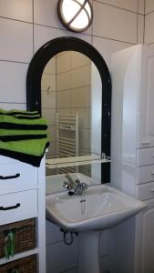 a bathroom with a sink and a mirror at Appartement centre-ville - gîte urbain avec jardin in Bastogne