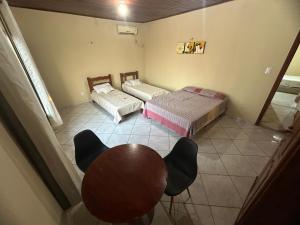 Una habitación con dos camas y una mesa dentro. en Flat Publio, en Marabá 11 fotos más