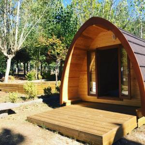 a small wooden cabin with a large window in a yard at Iglu holyday in San Amaro