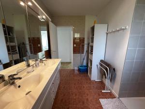 ein Badezimmer mit zwei Waschbecken und einem großen Spiegel in der Unterkunft Maison avec jardin près des Thermes, 2 chambres, équipements modernes, à La Roche-Posay - FR-1-541-33 in La Roche-Posay + 9 Fotos
