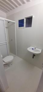a white bathroom with a toilet and a sink at RENTA APARTAMENTO EN EL RODADERO SANTA MARTA CERCA DEL MAR in Rodadero
