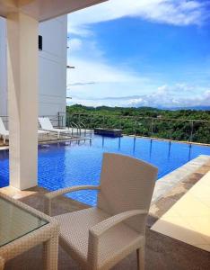 Un balcón con una silla y vista a una piscina. en Relax in Paradise Boracay Island, en Boracay