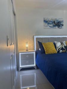 a bedroom with a blue bed and a night stand at Relaxing Studio Getaway w BBQ, Patio and Parking in Pembroke Pines